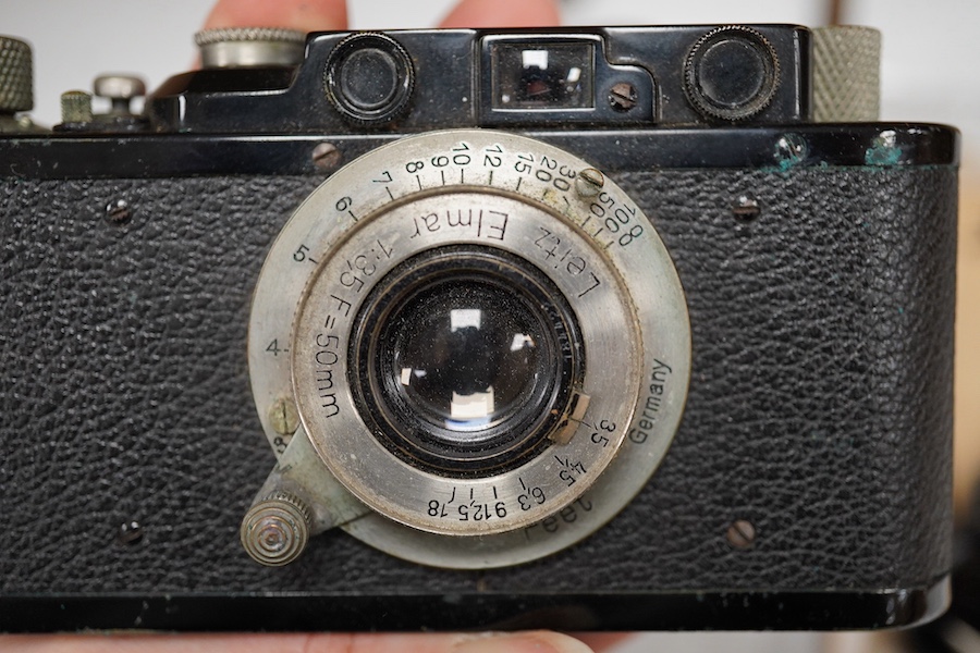 A Leica Model II camera in leather case, together with an Elmar 4.5/135mm lens, lens table booklet and instruction booklet. Condition - poor to fair.